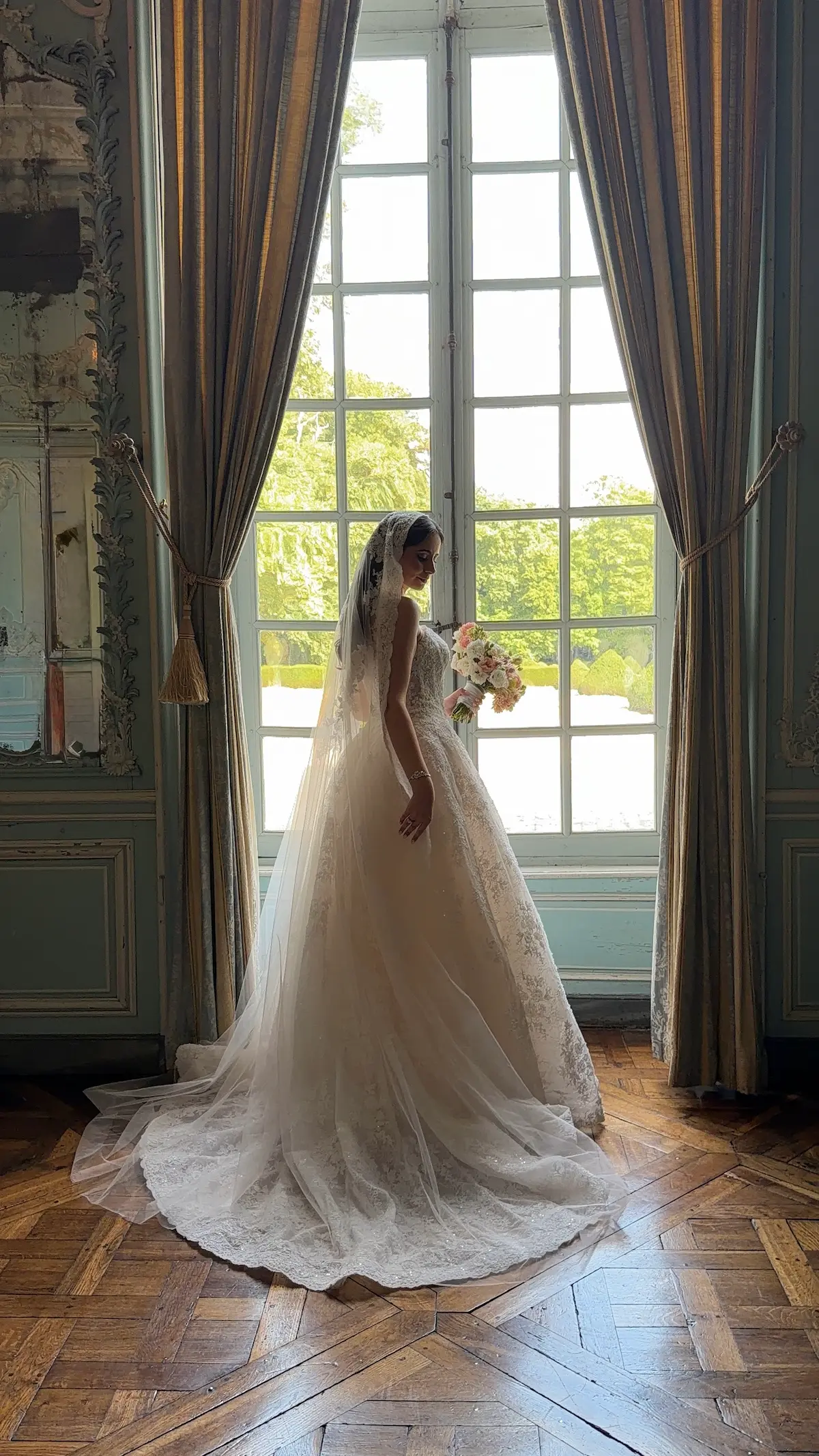 Mariée en train de se préparer devant une fenêtre